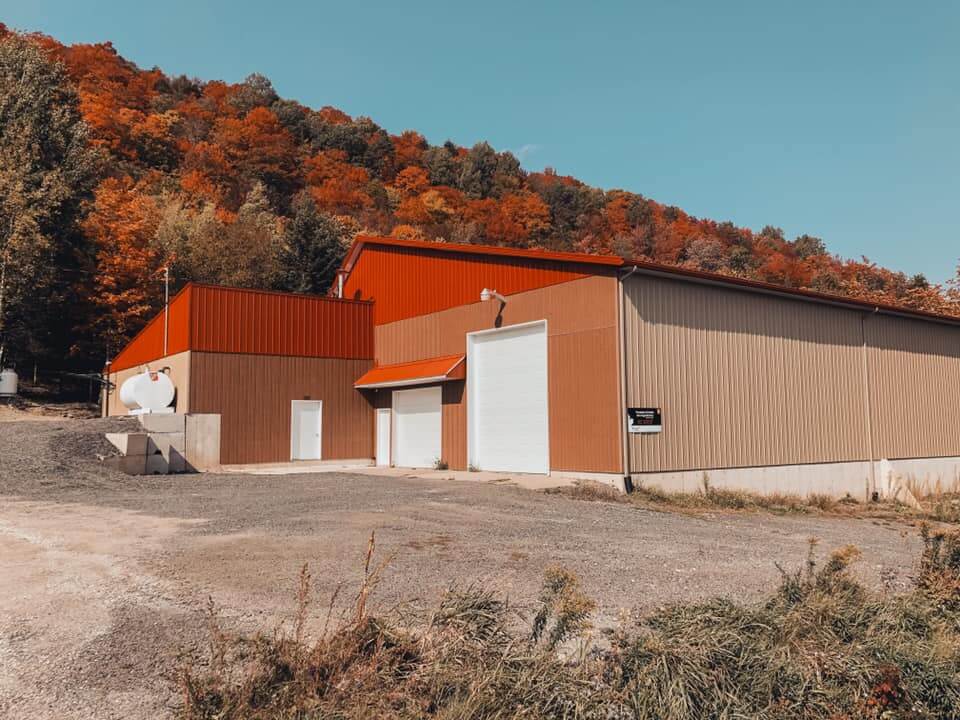 L'érablière des Produits d'érable des Appalaches vue de l'extérieur, avec les montagnes et les couleurs d'automne en arrière plan.