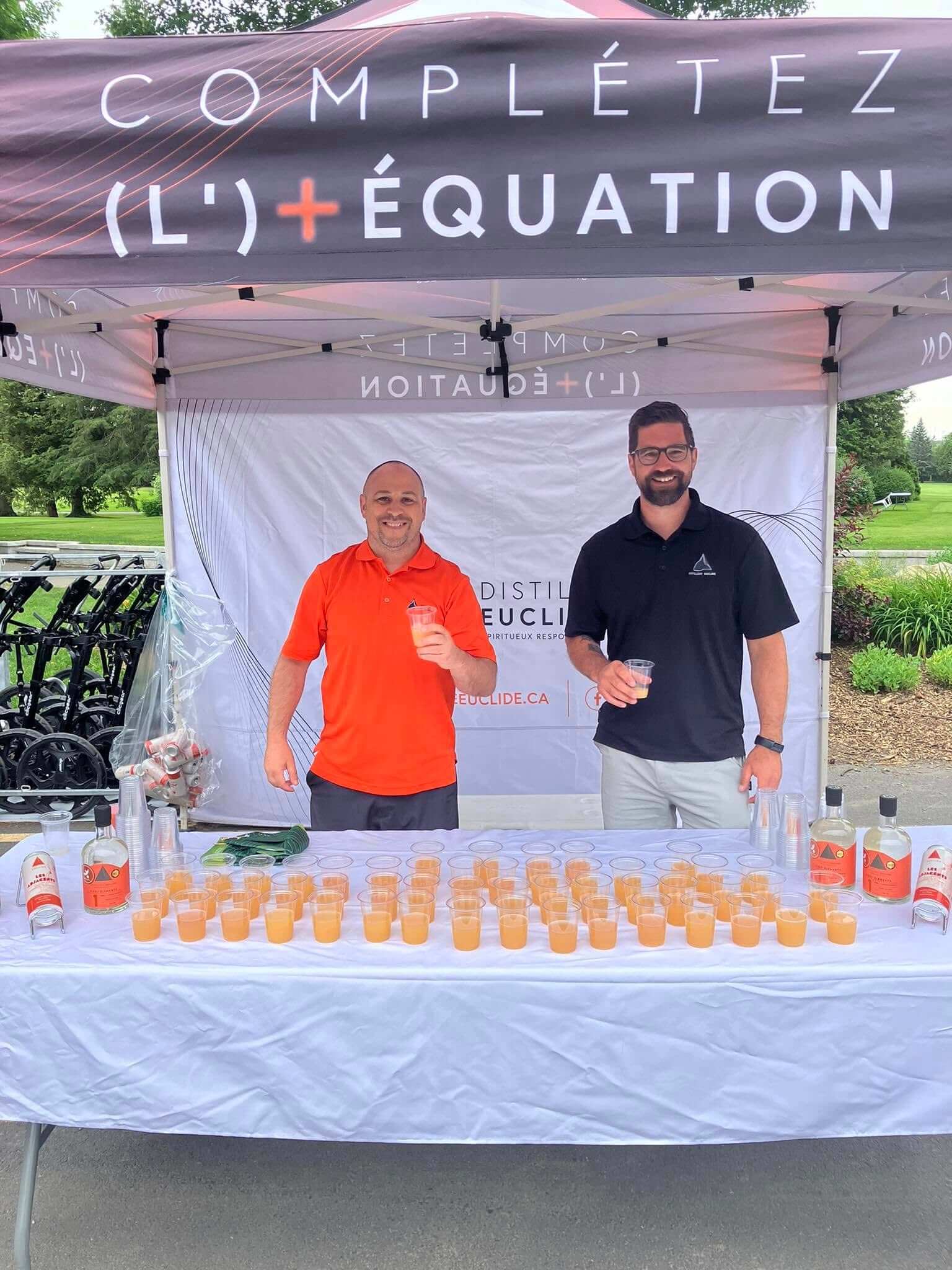 Les deux propriétaires de la Distillerie Euclide à un kiosque de dégustation extérieur.