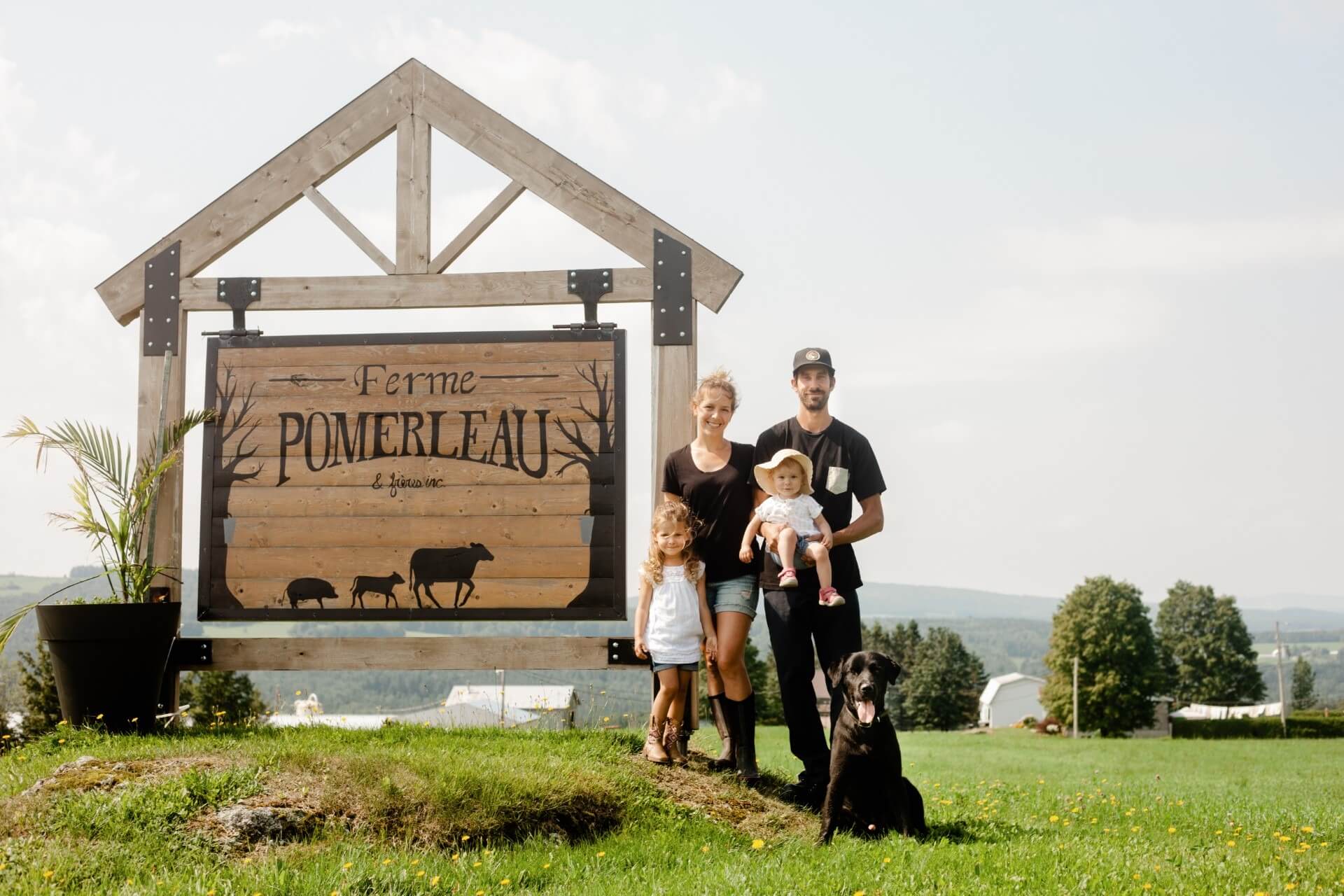 La famille derrière la Ferme Pomerleau et frères, photographiée devant l'enseigne.